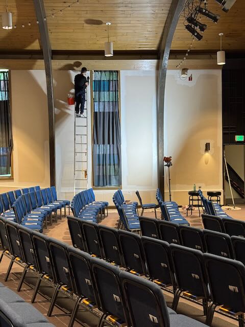 man painting a wall in a church